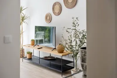 a living room with a console table with a mirror at Modern Apartment Steps From Beach in Ponta do Sol