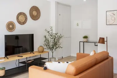 a living room with a couch and a tv at Modern Apartment Steps From Beach in Ponta do Sol