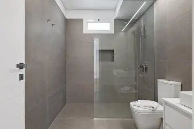a bathroom with a shower and a toilet and a sink at Modern Apartment Steps From Beach in Ponta do Sol