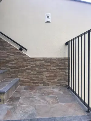 a stairwell with a stone wall and a clock on the wall at Vivenda Silva in Seixal