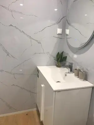 a bathroom with a white sink and a mirror at Vivenda Silva in Seixal