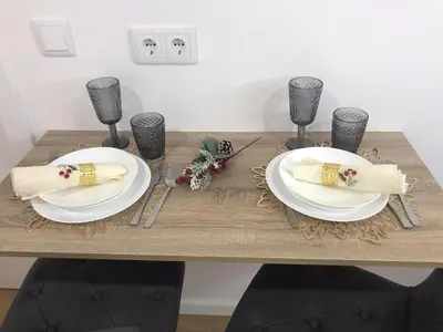 a wooden table with two white plates and napkins at Vivenda Silva in Seixal