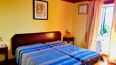 a bedroom with a bed with a blue comforter and a window at Sea View Villa in Calheta