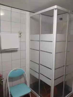 a blue chair in a bathroom with a shower at Sea View Villa in Calheta