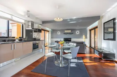 a kitchen and living room with a table and chairs at Baia da Luz - Upper Luz Suite in Luz