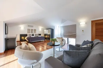 a living room with a couch and chairs and a bed at Baia da Luz - Upper Luz Suite in Luz