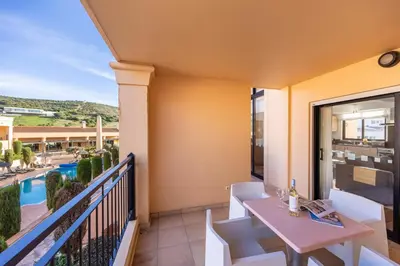 a balcony with a table and chairs and a pool at Baia da Luz - Upper Luz Suite in Luz