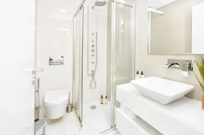 a white bathroom with a sink and a shower at Premium Avenue Two Bedrooms Apt in Funchal