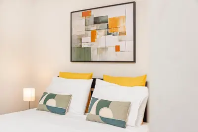 a bedroom with a white bed with a painting on the wall at Premium Avenue Two Bedrooms Apt in Funchal