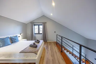 a bedroom with a large bed and a staircase at Santana Trail House - Pico Ruivo in Santana