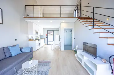 a living room with a couch and a staircase at Santana Trail House - Pico Ruivo in Santana