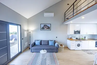 a living room with a couch and a kitchen at Santana Trail House - Pico Ruivo in Santana