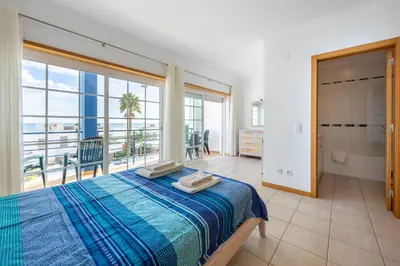 a bedroom with a bed with a view of the ocean at Lote 14 Fontainhas in Luz