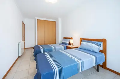 two beds in a room with blue and white sheets at Lote 14 Fontainhas in Luz