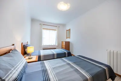a bedroom with a blue bed with towels on it at Lote 14 Fontainhas in Luz