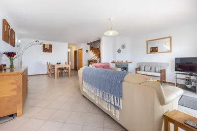 a living room with a couch and a tv at Lote 14 Fontainhas in Luz