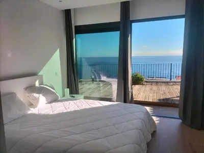 a bedroom with a bed and a view of the ocean at Villa Atlantic Lodjadis in Gaula