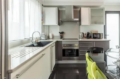 a kitchen with white cabinets and a sink at Apartamento Ruby in Machico