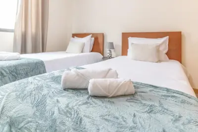 two beds with towels sitting on top of them at Apartamento Ruby in Machico