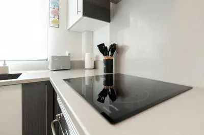 a kitchen counter with a black counter top with utensils at Apartamento Ruby in Machico