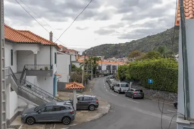 a street with cars parked on the side of the road at Apartamento Ruby in Machico
