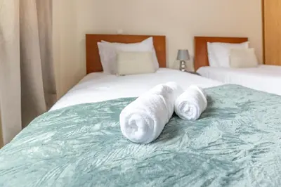 two rolled towels sitting on top of a bed at Apartamento Ruby in Machico