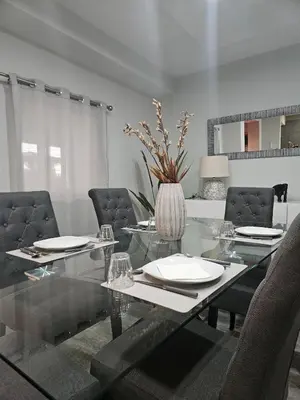a dining room with a glass table and chairs at Villa Barros in Câmara de Lobos