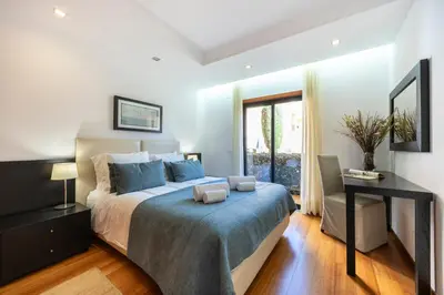 a bedroom with a bed and a desk and a window at Baia da Luz - Luz Suite in Luz