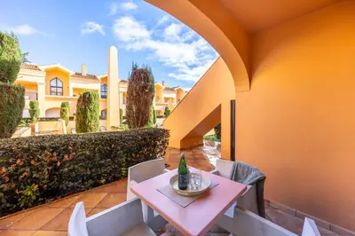 a table and chairs with a bottle on it on a patio at Baia da Luz - Luz Suite in Luz