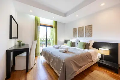 a bedroom with a large bed and a desk at Baia da Luz - Luz Suite in Luz