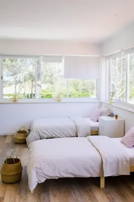 a bedroom with four beds and a window at Surf & Yoga Retreats Portugal in Aljezur