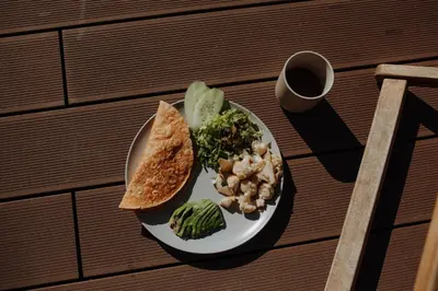 a plate of food with bread and vegetables on a table at Surf & Yoga Retreats Portugal in Aljezur