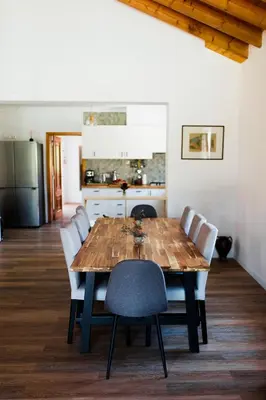 a dining room table with chairs and a kitchen at Surf & Yoga Retreats Portugal in Aljezur