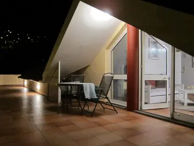 a dining room with a table and chairs and a window at Penthouse Marina Sol in Madalena do Mar