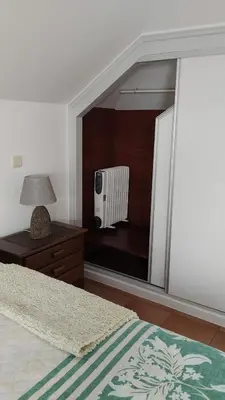 a bedroom with a mirror with a bed and a radiator at Penthouse Marina Sol in Madalena do Mar