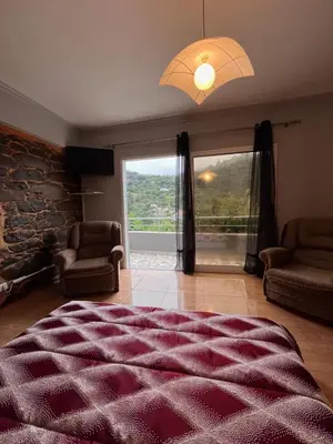 a bedroom with a large bed and a large window at Casa Duque - In the Heart of Santana Mountains in Santana