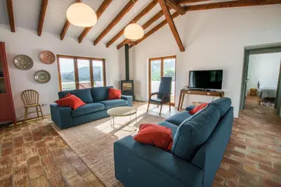 a living room with two blue couches and a television at Cabasina Bordeira in Bordeira