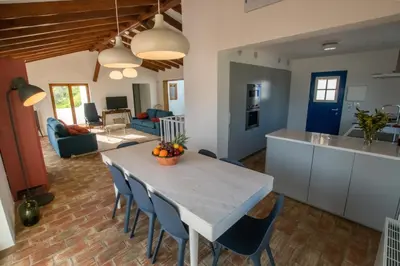 a kitchen and living room with a table and chairs at Cabasina Bordeira in Bordeira