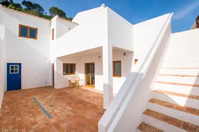 a white house with white walls and stairs at Cabasina Bordeira in Bordeira