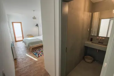a bathroom with a sink and a bed in a room at Cabasina Bordeira in Bordeira