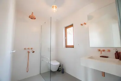 a white bathroom with a sink and a toilet at Cabasina Bordeira in Bordeira