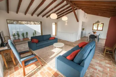 a living room with two blue couches and a table at Cabasina Bordeira in Bordeira