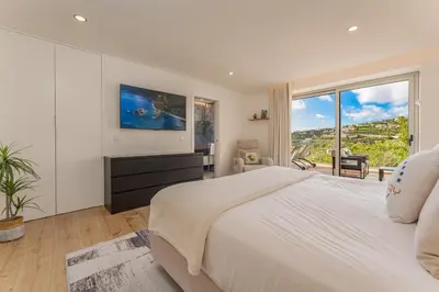 a white bedroom with a large bed and a large window at The Viewpoint by Eurostay in Ribeira Brava