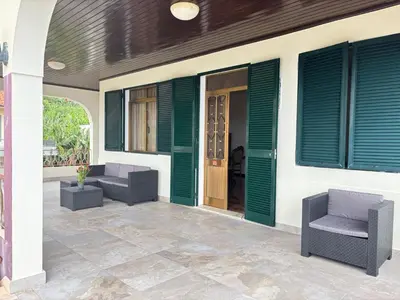 a patio with two chairs and green shutters on a house at Casa estrelicia II in Relógio do Poiso