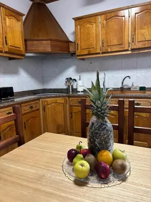 a bowl of fruit on a table with a pineapple at Casa estrelicia II in Relógio do Poiso