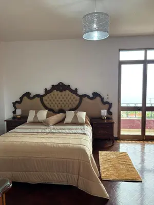 a bedroom with a large bed and a large window at Casa estrelicia II in Relógio do Poiso