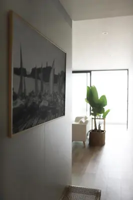 a living room with a painting on the wall and a plant at B View Madeira - Ocean & Bay View Apartment in Câmara de Lobos
