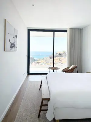 a bedroom with a large bed and a large window at B View Madeira - Ocean & Bay View Apartment in Câmara de Lobos