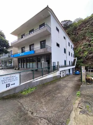 a white building with a sign in front of it at Ape T0 in São Vicente