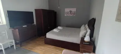 a bedroom with a bed and a dresser and a television at Ape T0 in São Vicente
